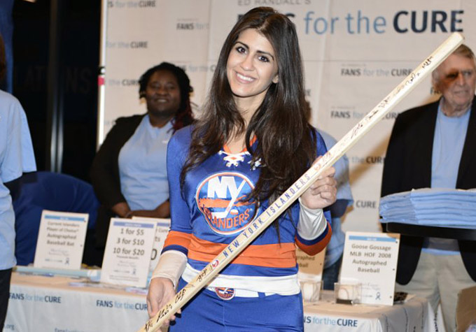 An NY Islanders Ice Crew holding an autographed hockey stick