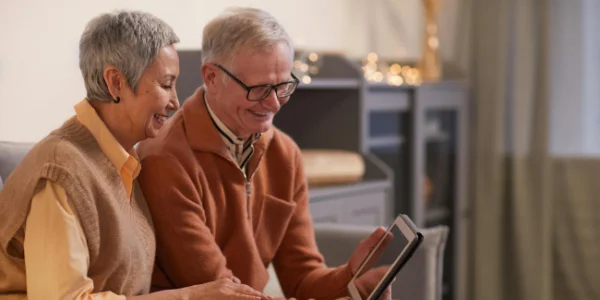 A couple sitting together and reviewing the contacts of a tablet