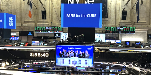 Fans for the Cure's logo displayed on large screens at the New York Stock Exchange