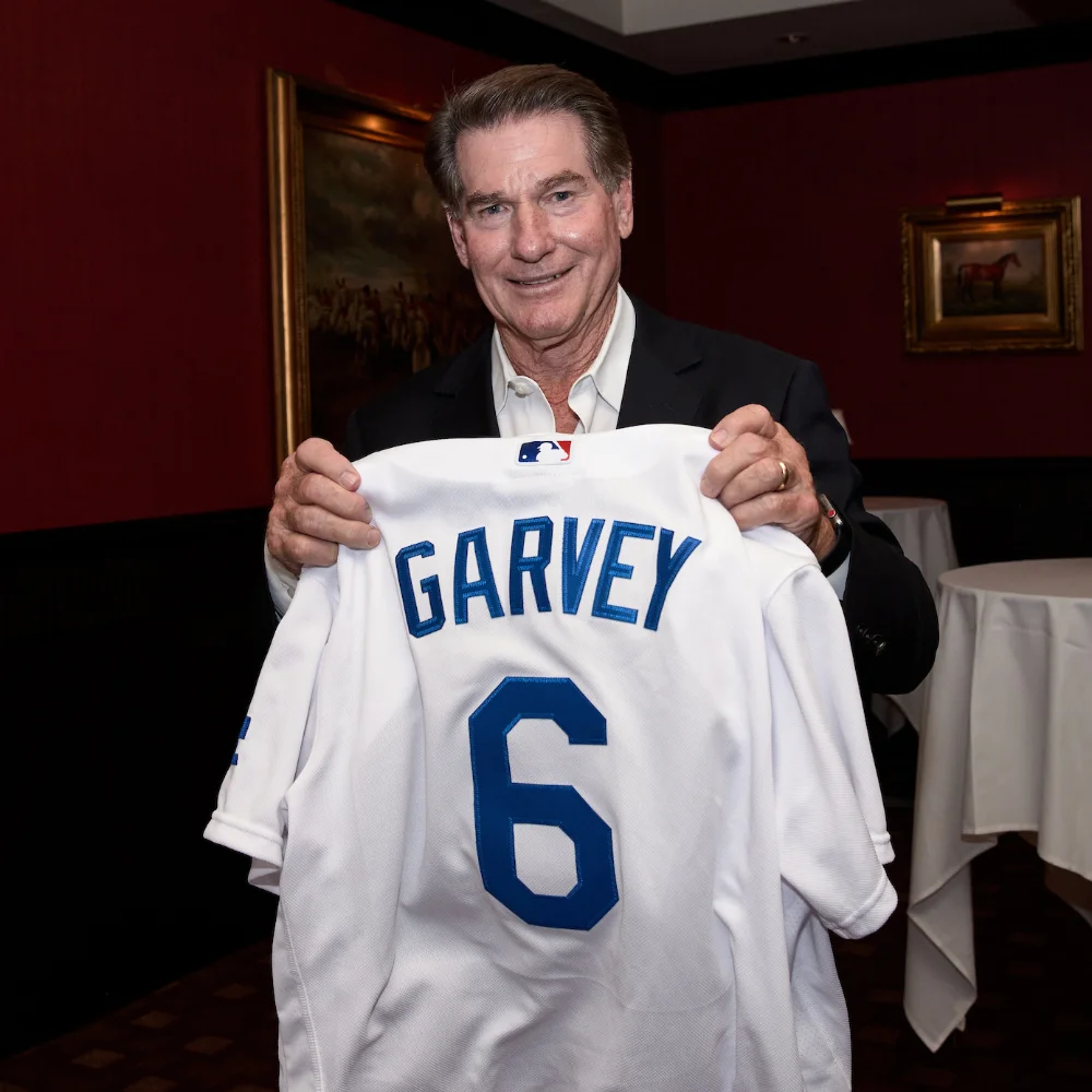 Steve Garvey holding a number 6 jersey.