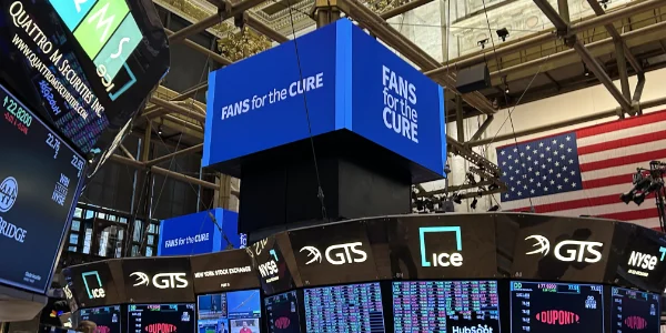 The Fans for the Cure logo on a big screen on the NY Stock Exchange floor.